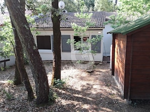 A small house with a tiled roof, surrounded by trees and a wooden shed. - 4-Person Pavilion in Private Park at Jard-sur-Mer (Jard-sur-Mer)