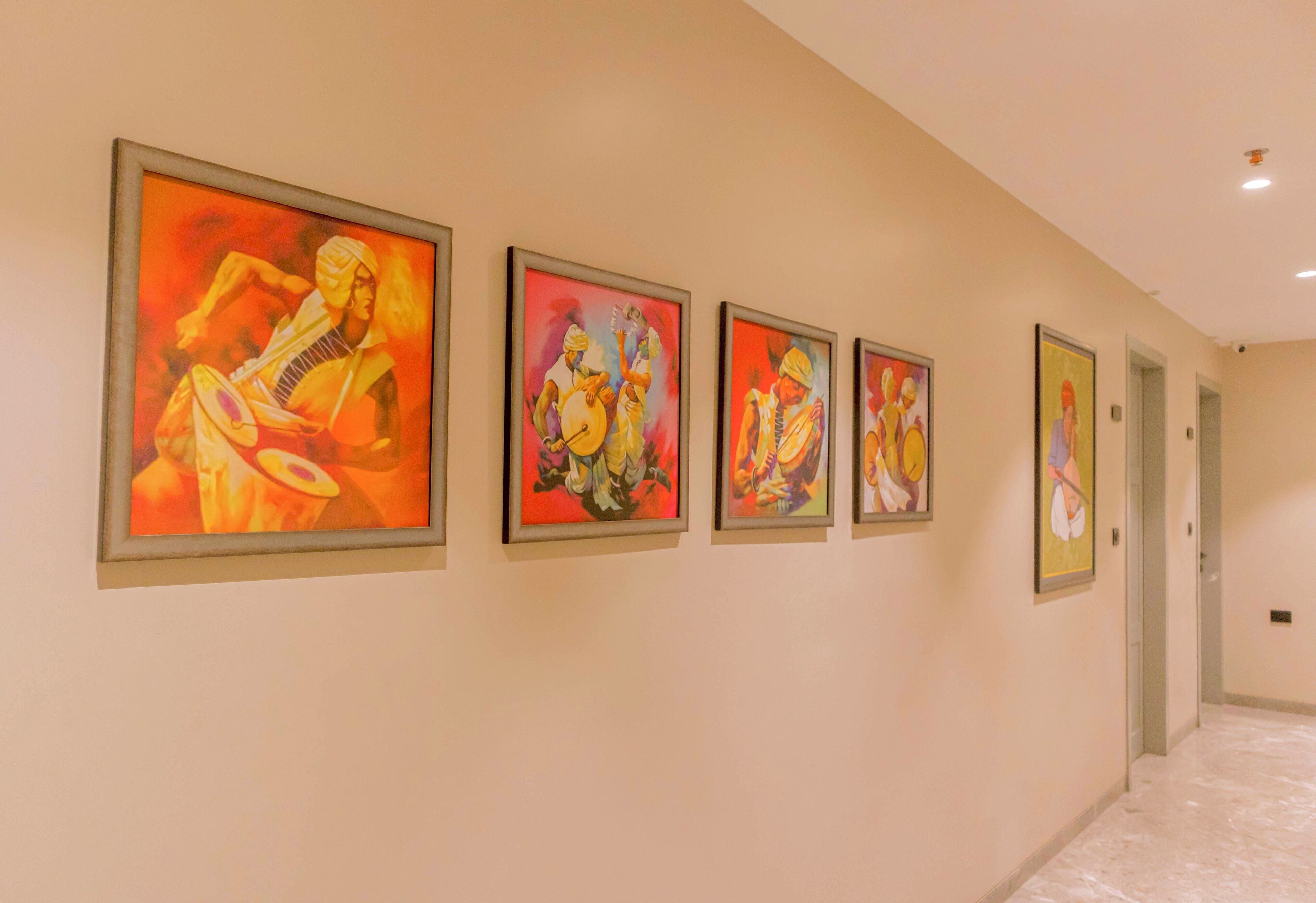 A hallway with four framed artworks on the wall.