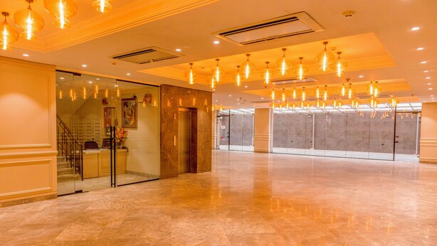 A spacious lobby with marble flooring, a reception desk, and a glass elevator. - The 12th Square Saltlake (Bidhannagar)