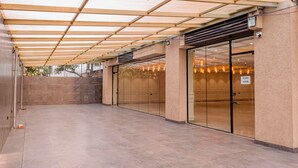 A covered outdoor area with a glass door, a pull handle, and a sign indicating it's a glass door. - The 12th Square Saltlake (Bidhannagar)