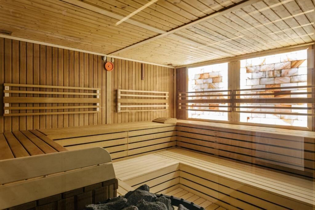 A wooden sauna with benches and a window.