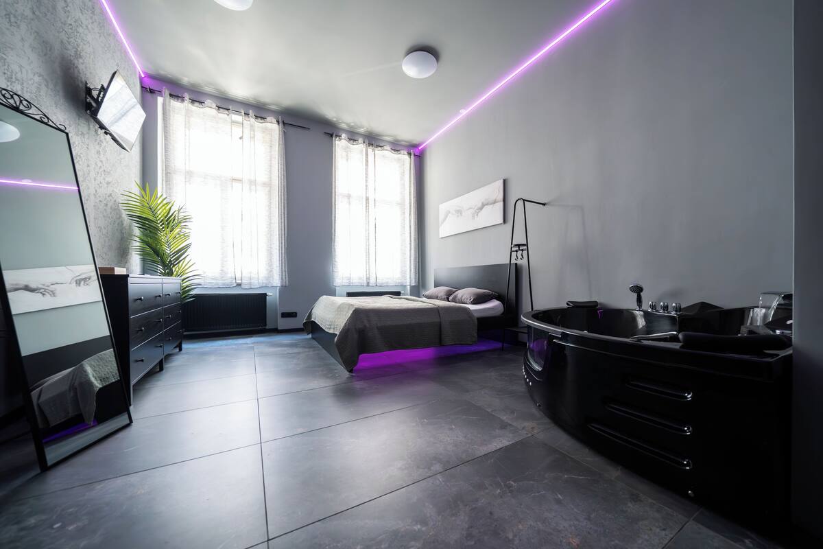 Un dormitorio moderno con cama, tocador y un amplio ventanal.