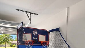 A basketball court with a blue floor, two hoops, and a net.
