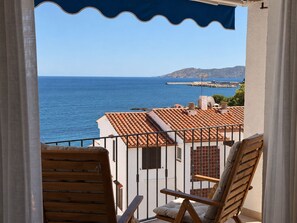 A balcony with a view of the sea and a distant mountain, featuring a tiled roof and two wooden chairs. - Apartment with terrace and sea view - 3 bedrooms - Llançà (Cap de Creus) (Llançà)
