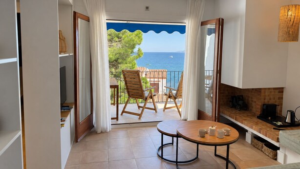 A balcony with a view of the sea, a round table with cups, and a sofa. - Apartment with terrace and sea view - 3 bedrooms - Llançà (Cap de Creus) (Llançà)