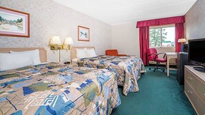 Habitación de hotel con dos camas, un escritorio, una silla, un televisor y una ventana con cortinas.