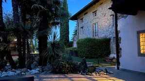 A stone building with a garden, a bench, and a pathway. - Residence San Bernardo - Apt. "Magalita" in the countryside, 6 km from the center of Udine (Udine)