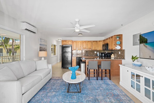 A modern kitchen with wooden cabinets, a white countertop, and a bar area.