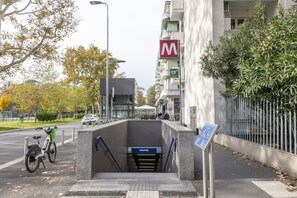 Een gevel met een fietsenstallingsplaats, een trap en een bord dat een locatie aangeeft.