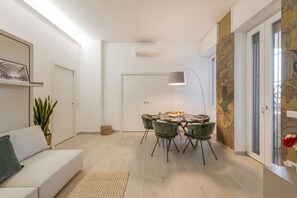 Ein modernes Interieur mit Essbereich, Sofa und einer Pflanze.
