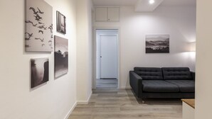Een modern interieur met een grijze bank, kunstwerken aan de muur en een houten vloer.