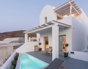 Una villa moderna bianca con piscina, area relax esterna e vista sul paesaggio.