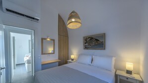 Un dormitorio con cama, mesitas de noche, lámpara, espejo y un cuadro colgado en la pared.