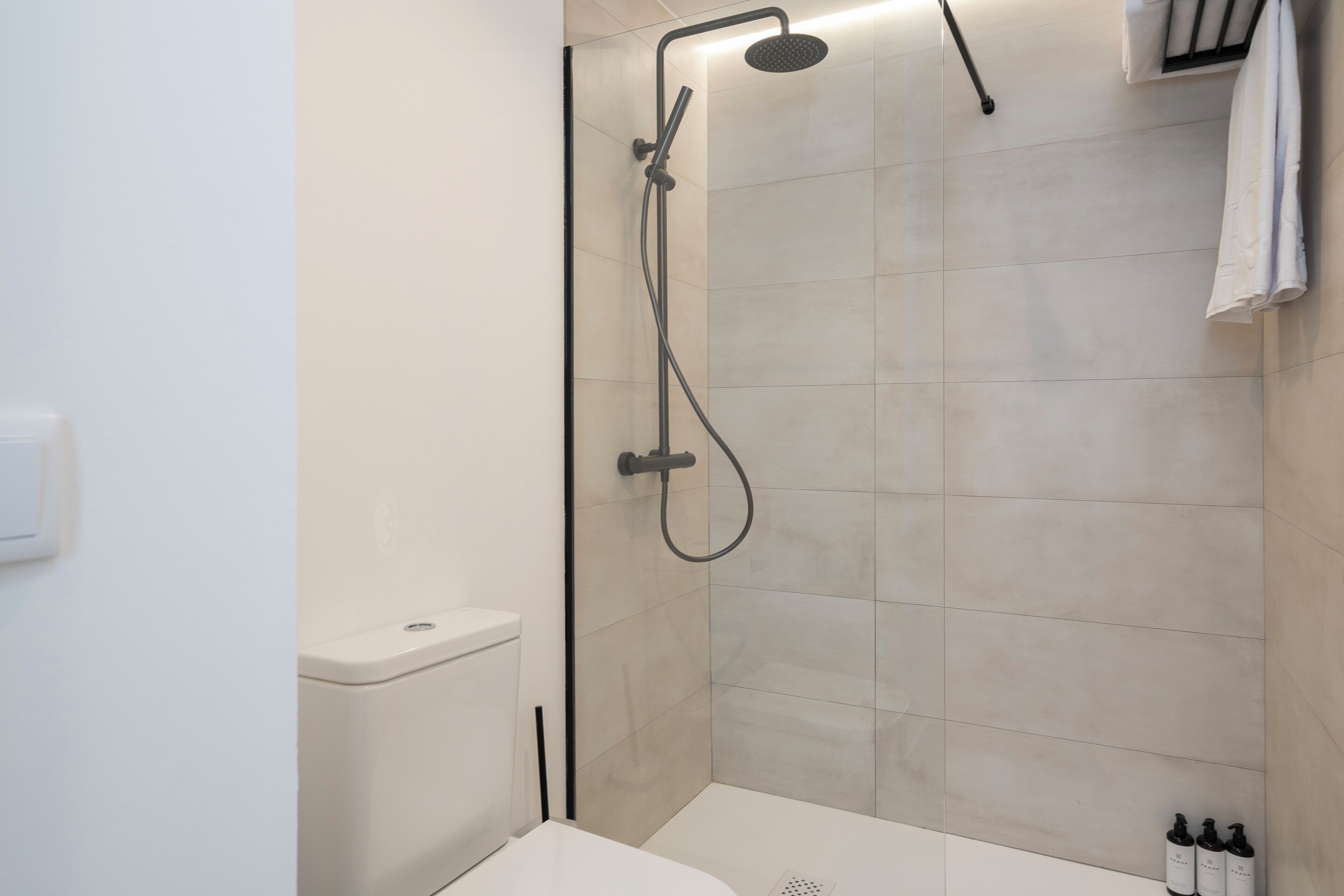A modern bathroom with a shower, toilet, and sink.