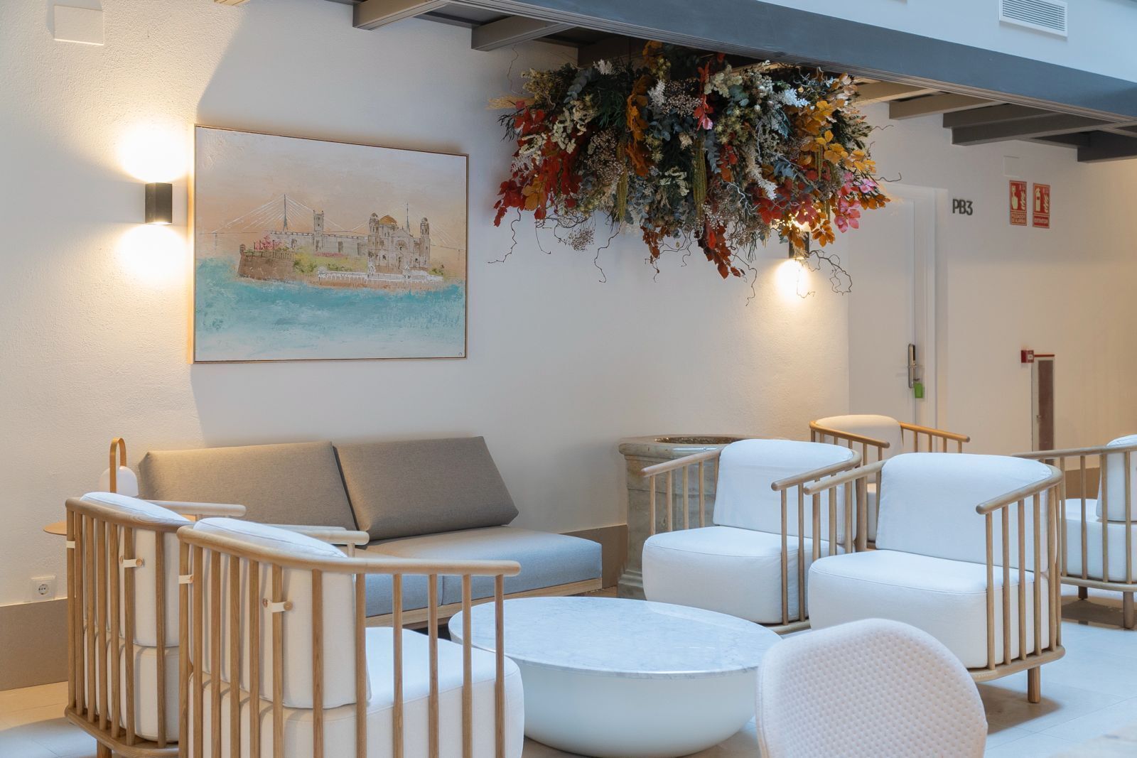 Een modern interieur met een bank, stoelen en een bloemarrangement.