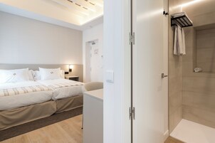 Ein Hotelzimmer mit Bett, Schreibtisch und Duschbereich.