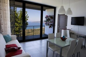 Departamento superior, balcón, vista al mar | Área de sala de estar | Televisión 