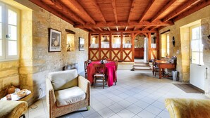 A rustic dining area with a wooden ceiling, stone walls, and a tiled floor. - Stone house at the foot of La Vézère, for 6 (Saint-Léon-sur-Vézère)