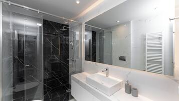 Deluxe appartement, keuken | Badkamer | Een douche, een regendouche, een haardroger, handdoeken
