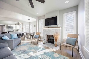 A modern living room with a fireplace, a flat-screen TV, and a dining area. - 4BR house - West OC, Harbor /Assateague- sleeps 9 (Ocean City)