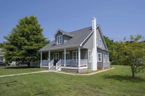 A two-story house with a porch, a chimney, and a well-maintained lawn. - 4BR house - West OC, Harbor /Assateague- sleeps 9 (Ocean City)