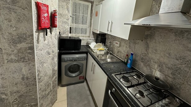 Cocina compacta con lavadora, estufa y microondas.