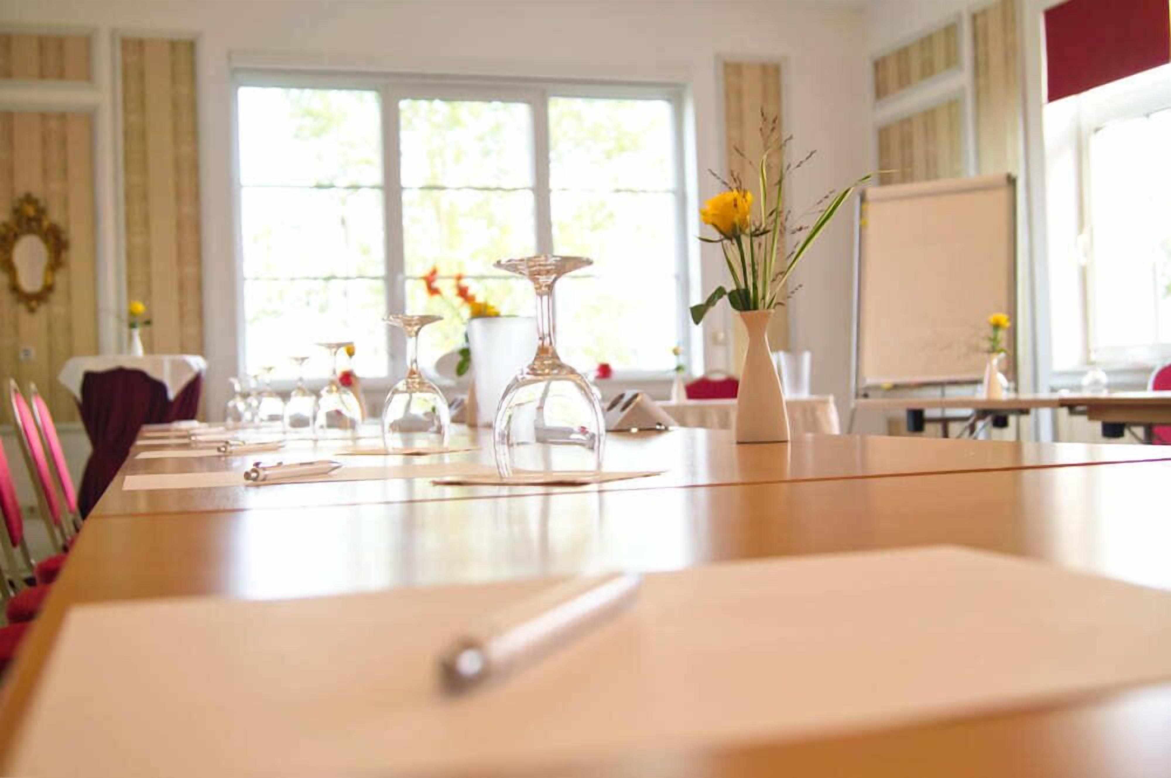 A conference room with a long table, chairs, and a whiteboard.