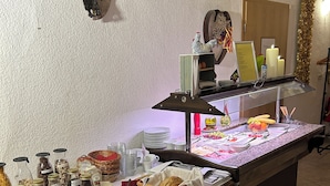 A buffet setup with various food items, condiments, and a decorative wall piece. - Fürstenhof Landgasthaus und Hotel (Erfurt)