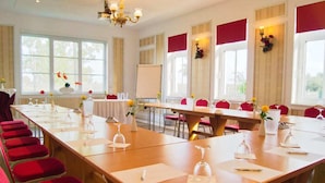 A conference room with long tables, red chairs, and a whiteboard. - Fürstenhof Landgasthaus und Hotel (Erfurt)