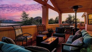 A covered outdoor seating area with a fire feature, chairs, and a view of the landscape. - 5 Bed, 3 Bath Uptown Sedona-Game Room-Sauna-Cold Plunge-Jacuzzi-Gym (Sedona)