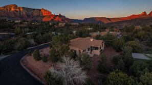 A residential area with houses, a winding road, and a prominent mountain range in the background. - 5 Bed, 3 Bath Uptown Sedona-Game Room-Sauna-Cold Plunge-Jacuzzi-Gym (Sedona)