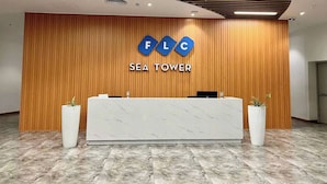 Un comptoir d’accueil avec un panneau en bois et une enseigne indiquant « FLC SEA TOWER ».