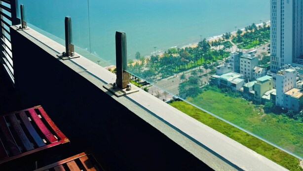 Un balcon offrant une vue dégagée sur la mer et le paysage urbain.