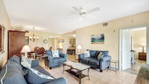 A spacious living room with two sofas, a coffee table, and a ceiling fan. - Vanderbilt Villas (Naples)
