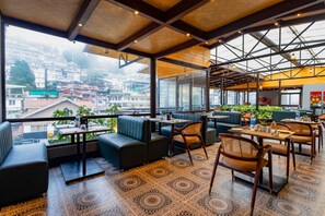A restaurant with a terrace, seating area, and patterned flooring. - Sumitel JB Park Darjeeling  (Darjeeling)
