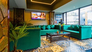 A modern living room with a green sofa set, a glass coffee table, and patterned floor tiles. - Sumitel JB Park Darjeeling  (Darjeeling)