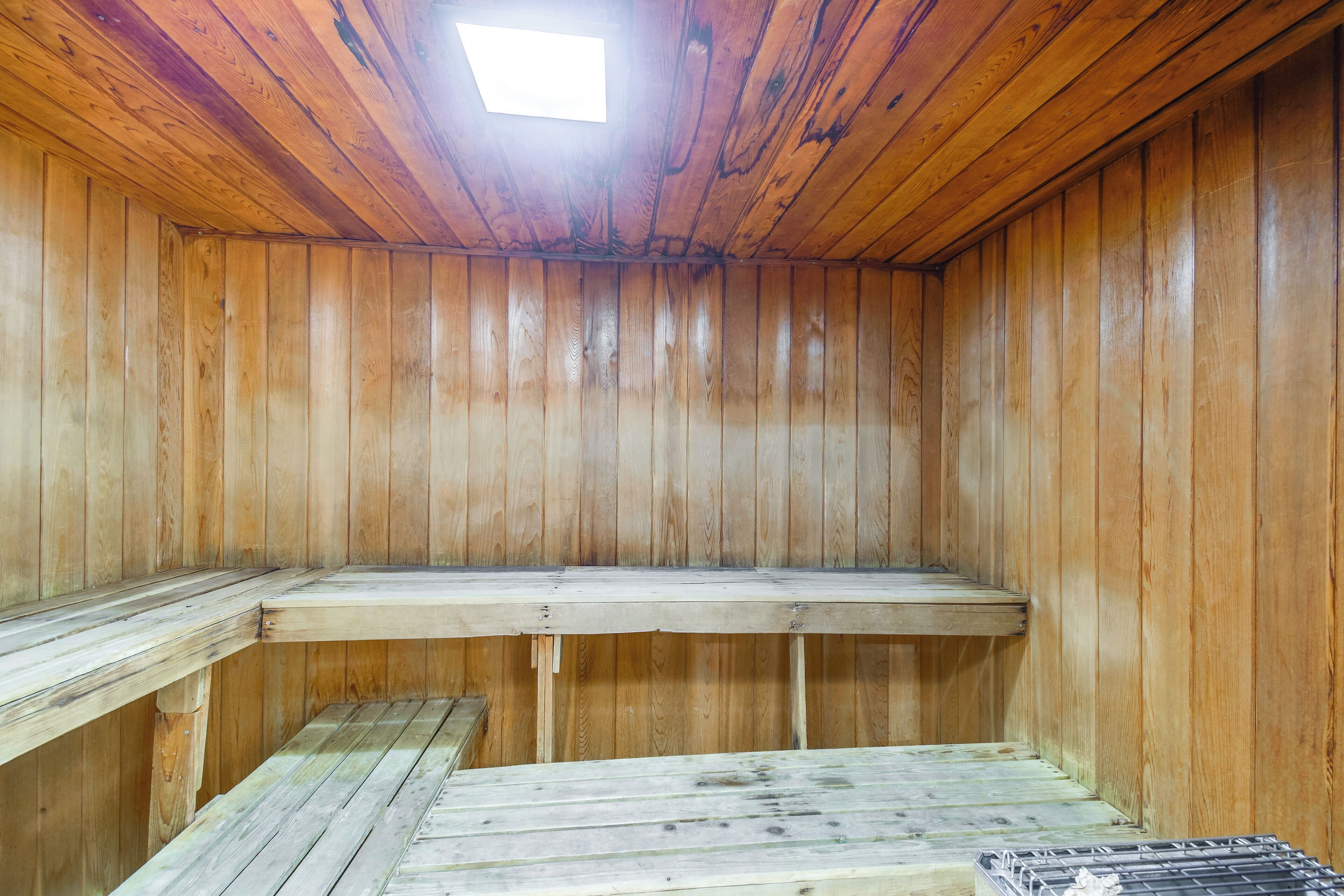 A wooden sauna with benches and a skylight.