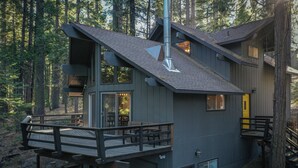 Une cabane à plusieurs niveaux, dotée d’une terrasse, d’une cheminée et d’une porte de garage.