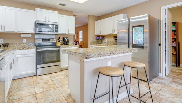 A modern kitchen with white cabinets, stainless steel appliances, and a granite countertop. - 6 Mi to Lake Travis: Spacious Cedar Park Home! (Cedar Park)