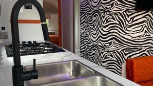 A modern kitchen with a stainless steel sink, a gas stove, and a black faucet.