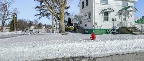 Un edificio bianco con tetto verde, un idrante rosso e terreno innevato.