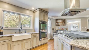 A modern kitchen with a large island, built-in ovens, and a stainless steel range hood. - 4 Mi to Dtwn Tuscaloosa: Home w/ Cozy Den! (Tuscaloosa)