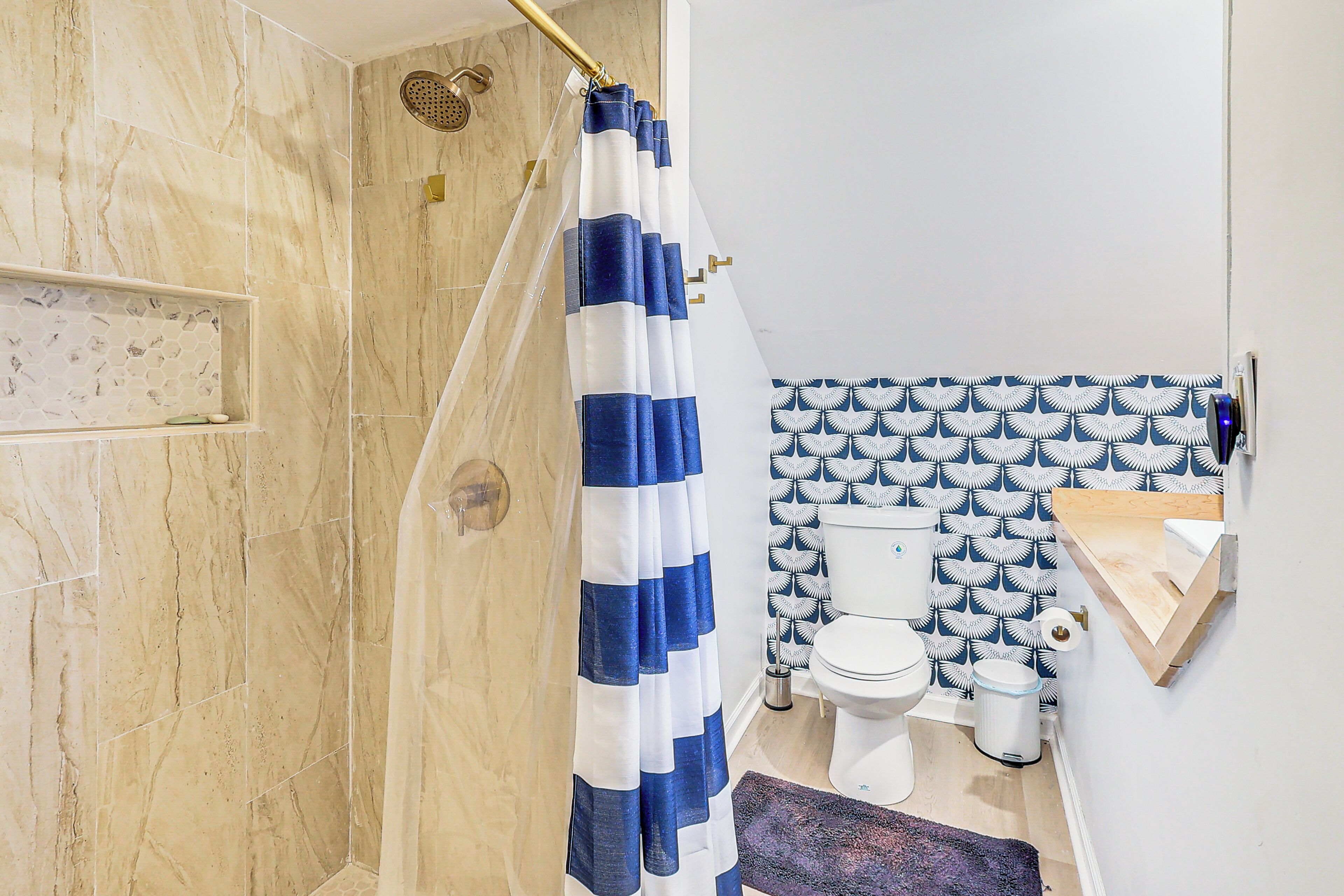 A bathroom with a shower, toilet, and sink.