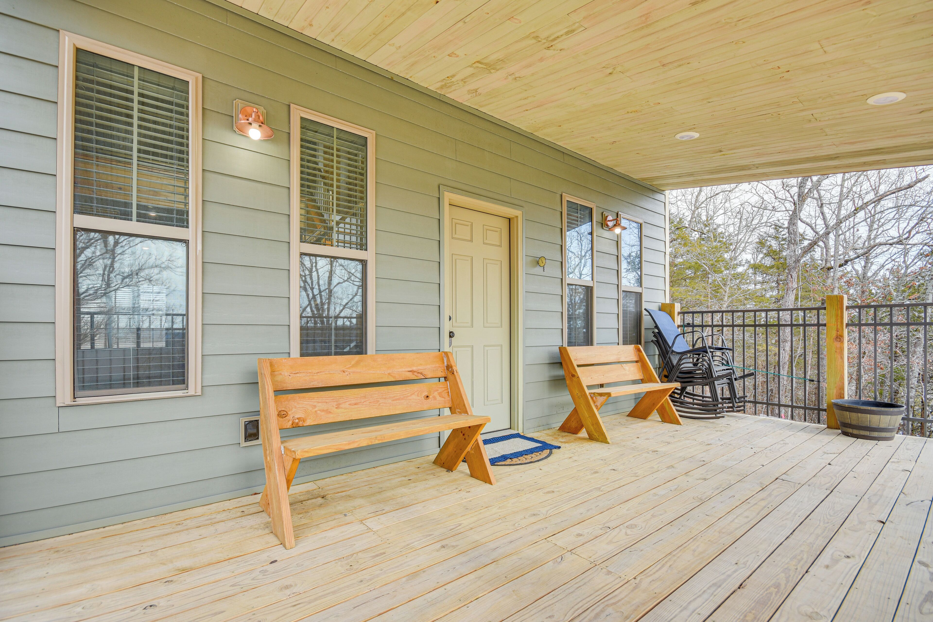 A wooden deck with two benches and a door.