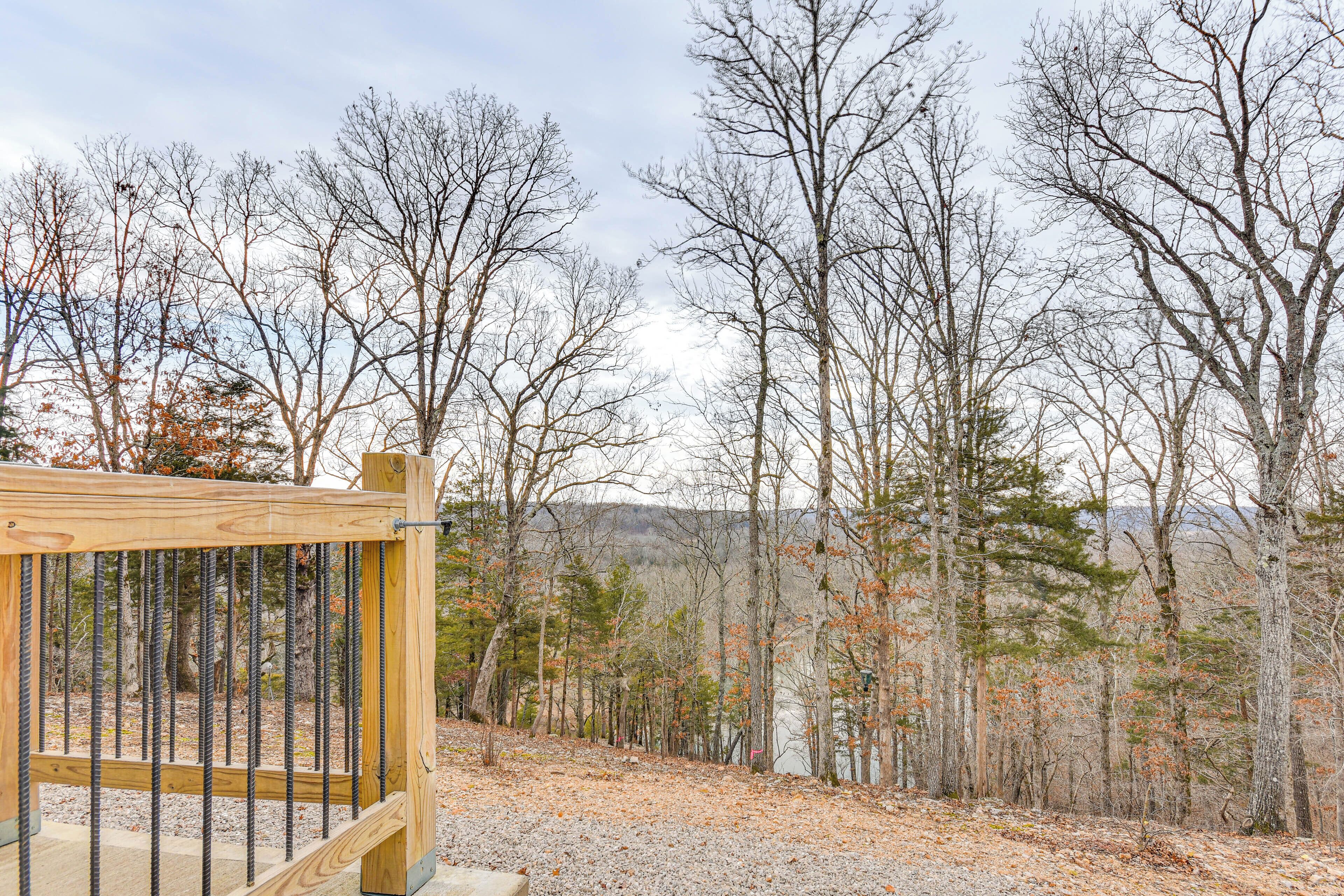 A wooden gate leading into a forested area with a gravel path.