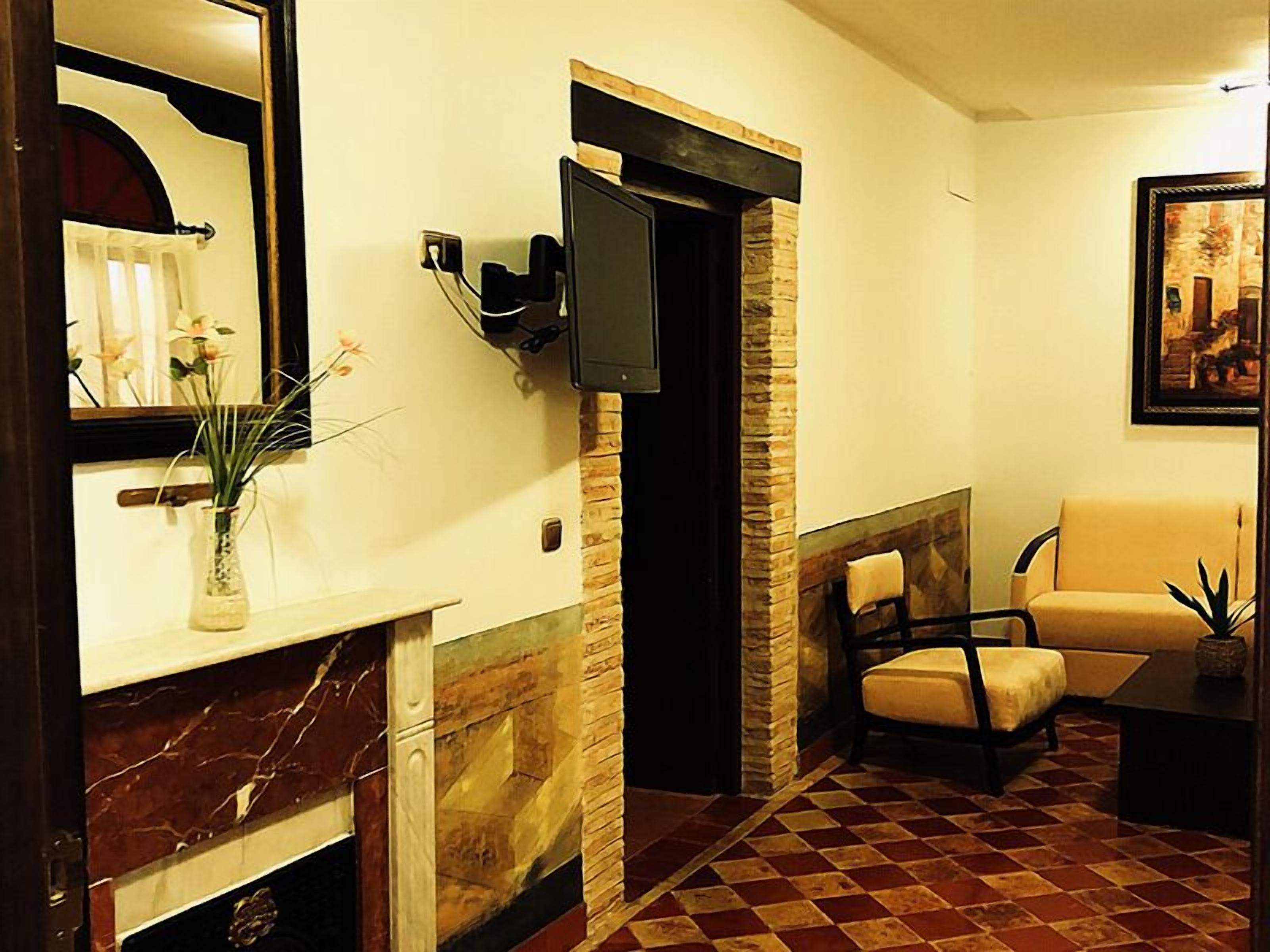 Un salon avec une cheminée, un téléviseur fixé au mur, un canapé et un fauteuil.