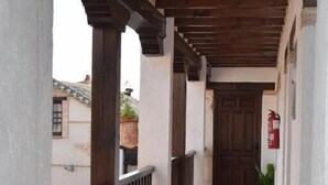 Ein Korridor mit Holzbalken, weißen Wänden und einem gefliesten Boden.