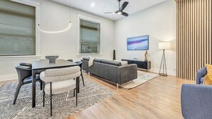 En moderne stue med spisebord, sofa og loftsvifte.