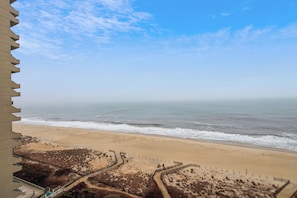 Vista de la playa desde un edificio alto, con cielo despejado.