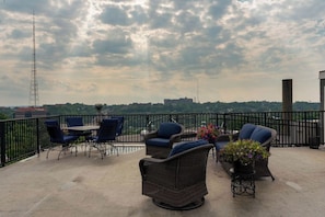 A balcony with wicker furniture, a table, and potted plants. - Retro Modern 2 Bdrm 2 Bath Condo (Cincinnati)